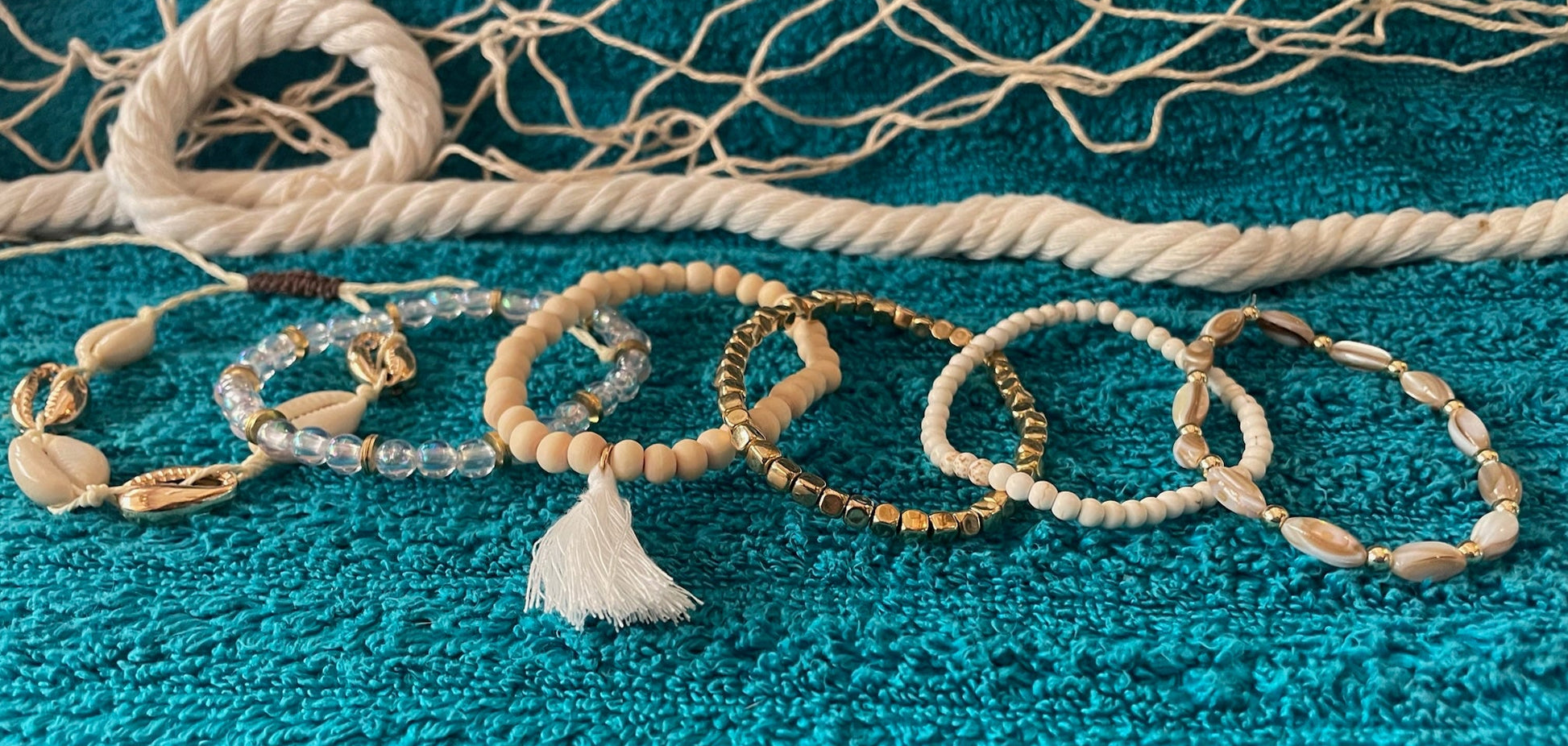 Set of beaded bracelets on a textured blue surface with a fishing net in the background