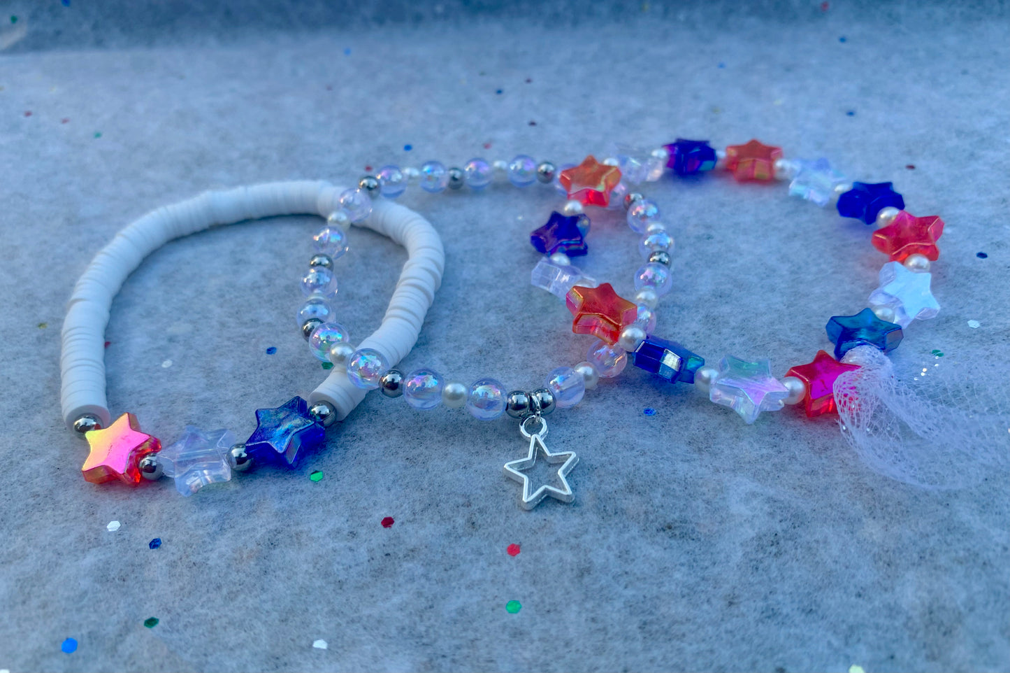 Colorful beaded necklace with star beads and charms on a textured surface
