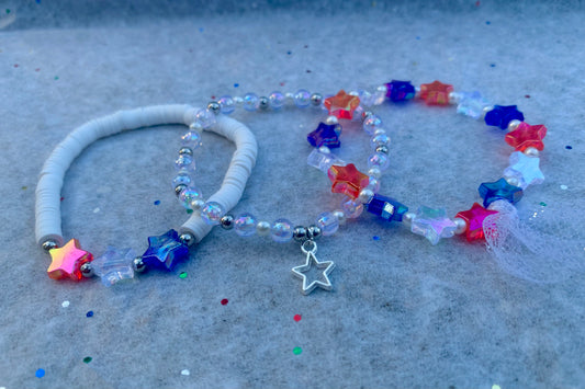 Colorful beaded necklace with star beads and charms on a textured surface