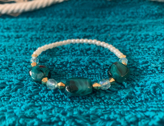 Beaded bracelet with blue and clear beads on a textured blue surface