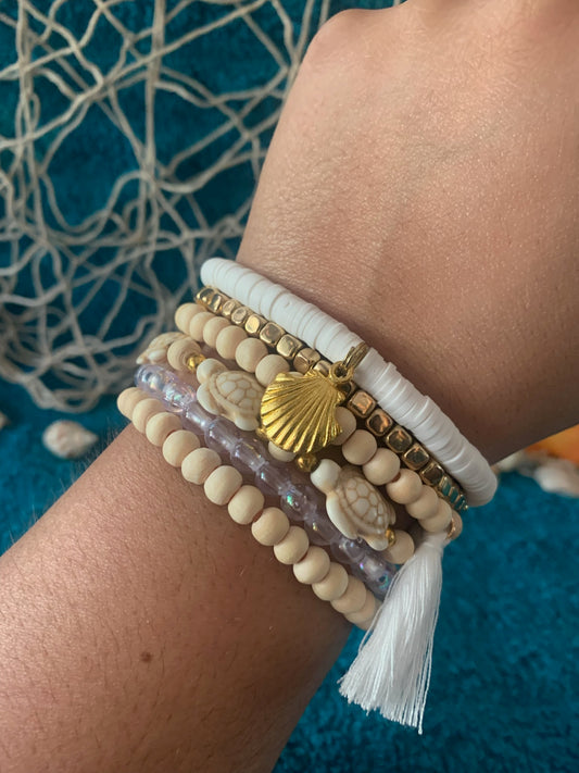 Close-up of a wrist wearing multiple beaded bracelets with a blue textured background